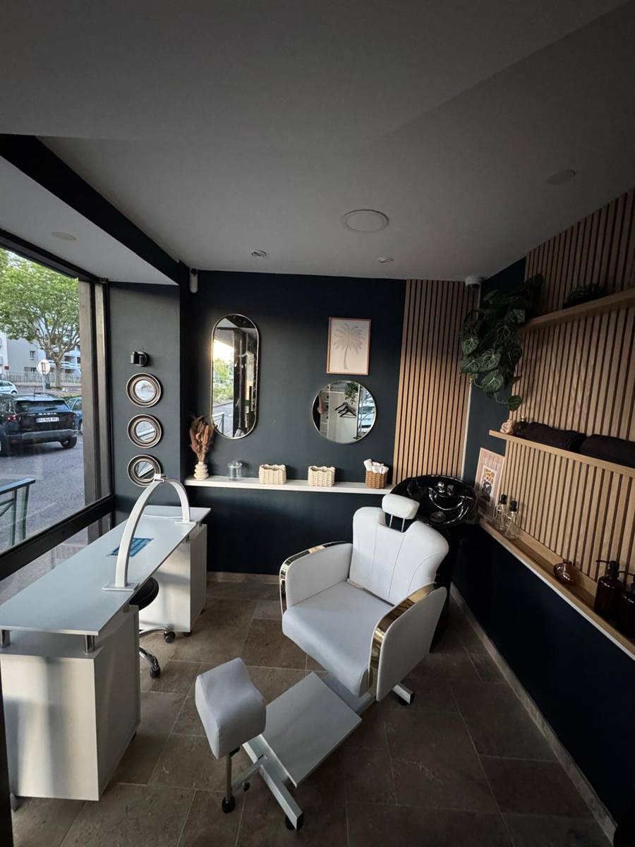 Le nouvel espace Coworking Beauté de la Laverie Jaurès au Petit-Quevilly : table de manucure blanche avec sa grande lampe arc, fauteuil de bac blanc et or, miroirs dorés et grande vitrine lumineuse.